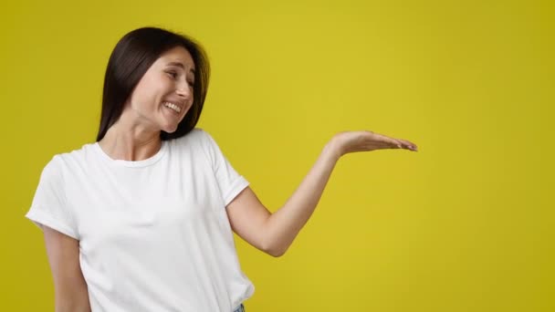 Video Mujer Joven Presentando Algo Sobre Fondo Amarillo Concepto Presentación — Vídeos de Stock