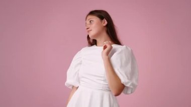 4k yakın plan videosu, sarı arka plan üzerinde düşünen ve aşağıya bakan genç bir kadın. Düşünce kavramı.