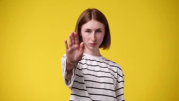 Video Ung Kvinna Visar Stopp Tecken Isolerad Över Gul Bakgrund — Stockvideo