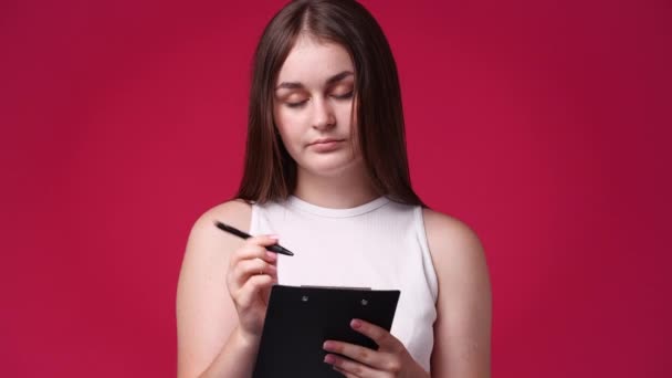 Video Mujer Concentrada Escribiendo Algo Aislado Sobre Fondo Rojo Concepto — Vídeo de stock