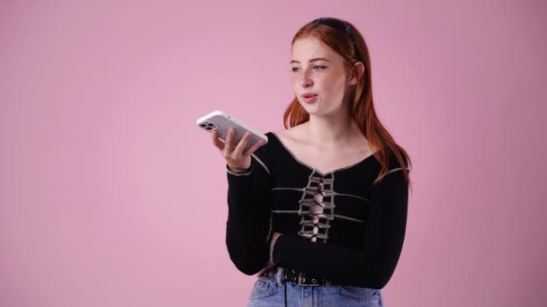 Video Mujer Linda Viendo Algo Teléfono Aislado Sobre Fondo Rosa — Vídeo de stock