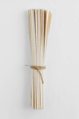 Beyaz arka planda bir demet yaylı spagetti makarna.