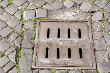 Yolda eski bir ızgara var. Roma yağmur kanalizasyonu. Eski bir taş kaldırım taşının yağmur suyu toplamak için yapılmış metal ızgarası vardır..