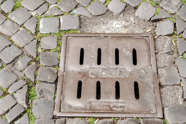 Yolda eski bir ızgara var. Roma yağmur kanalizasyonu. Eski bir taş kaldırım taşının yağmur suyu toplamak için yapılmış metal ızgarası vardır..