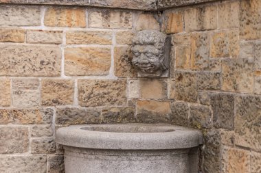 Bas-reva evin köşesinde. Taş bir kafada çok sinsi bir bakış..