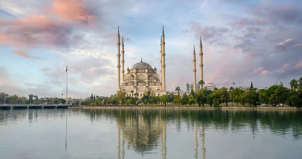 Seyhan Nehri üzerindeki Türkiye 'nin Adana kentindeki Sabancı Merkez Camii. Güneşli bir günde mavi gökyüzü caminin yansımaları var.
