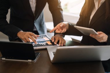 İş ortakları yeni bir başlangıç projesinde belge ve fikirleri akıllı telefon ve dijital tablet ve grafik işiyle tartışıyor. Finans görevi