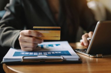 Akıllı telefon, tablet ödemeleri ve kredi kartı online alışveriş, omni kanal, Sun Ligh 'deki ofiste dijital tablet kenetleme klavyesi bilgisayarı kullanan iş kadını.