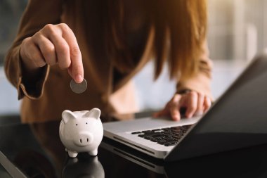 Domuz kumbarasıyla el ele tutuşan kadın. Tasarruf ve mali hesaplar onayı