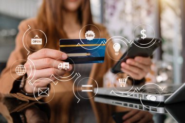 Mobil ödemeler için akıllı telefon kullanan bir kadın çevrimiçi alışveriş, Omni kanalı, masada oturan, sanal simge grafiksel arayüz çizelgesi