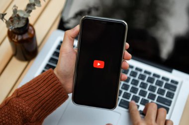  Chiang Mai Tayland. 28 Ocak 2022: Video servis YouTube 'lu iPhone tutan kadın. iPhone Apple tarafından oluşturuldu ve geliştirildi..