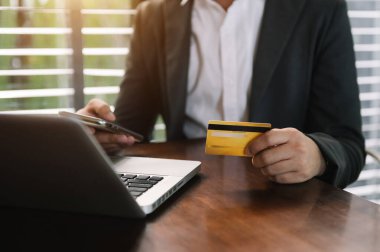 Akıllı telefon, tablet ödemeleri ve kredi kartı online alışveriş, omni kanal, dijital tablet kenetleme klavye bilgisayarı kullanan iş kadını.