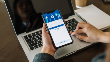 Chiang Mai Tayland. 24 Şubat 2022: Kadın ekranında facebook uygulaması olan akıllı bir telefon tutuyor. Facebook akıllı telefon için fotoğraf paylaşım uygulamasıdır