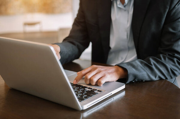 Man hands is typing on a laptop and holding tablet at offic