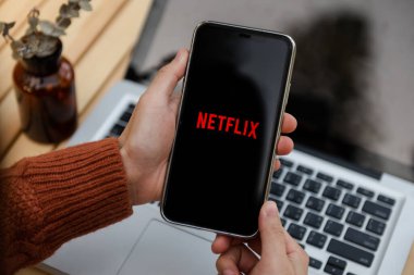  Chiang Mai Tayland. 25 Mart 2022: Çok uluslu eğlence şirketi Netflix ile iPhone 11 Pro Max 'i elinde tutan kadın ekranda yayın yapan medya ve video sunuyor.