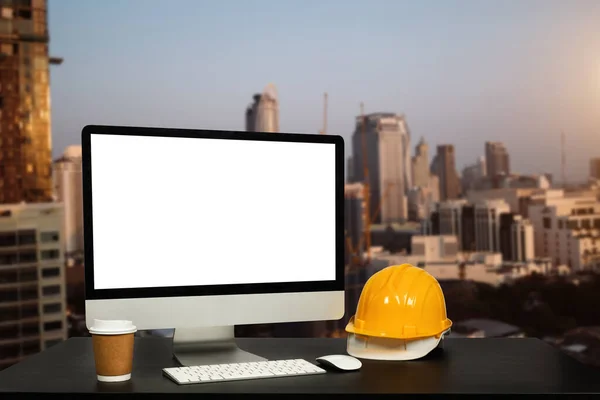 オフィスのテーブルの上にワークスペースのコンピュータを置くとオフィスの建設は 都市の背景をぼやけている — ストック写真