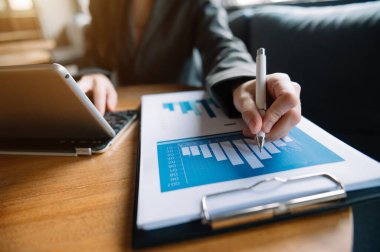 İş adamı dijital tablet bilgisayar ve akıllı telefon ile çalışıyor. Finansal iş stratejisi katmanı etkisi sabah güneşinde masada.