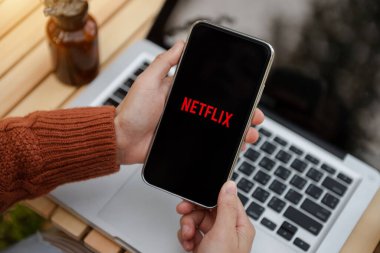  Chiang Mai Tayland April 21, 2022: Çok uluslu eğlence şirketi Netflix ile iPhone 11 Pro Max 'i elinde tutan kadın ekranda yayın yapan medya ve video sunuyor
