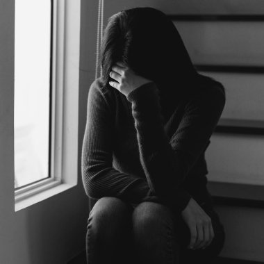  Kadın depresyonda. Pencere kenarında duruyor ve endişe duyuyor. Boşluğu kopyala..