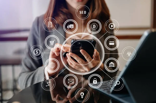 İş kadını ya da tasarımcı cep telefonu, dizüstü bilgisayarı ve dijital tablet bilgisayarı kullanıyor ve sabah kalktığında sanal simgeler ağı diyagramı ile birlikte masadaki belgeyi kullanıyor.