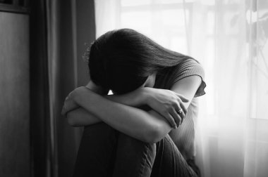 Kadın depresyonda. Pencere kenarında duruyor ve endişe duyuyor. Boşluğu kopyala.. 