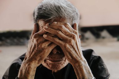 Üst düzey bir adam elleriyle yüzünü kapatıyor. Depresyon ve endişe Boşluğu kopyala