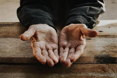 Kırış kırış erkek ellerine yaklaş, yaşlı adam ahşap masaya takıyor.