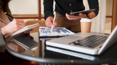 businessman and businesswoman brainstorming in office, laptop on desk 