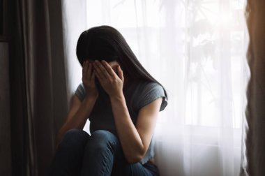 Depresyondaki ağlayan kadın evde yüzünü kapatıyor. 