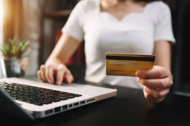 Ofis masası, masada çalışan kişi, dizüstü bilgisayar kullanan kadın, kredi kartı ile ödeme. 
