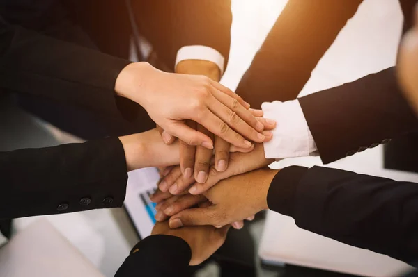 business team holding hands together, partnership support