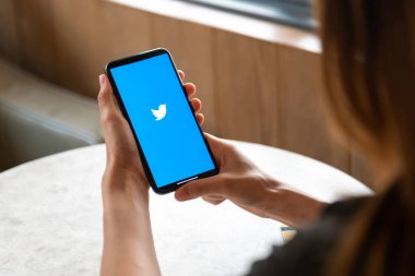 woman Holding Smartphone and using Twitter Application
