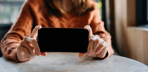 woman showing black empty screen of mobile