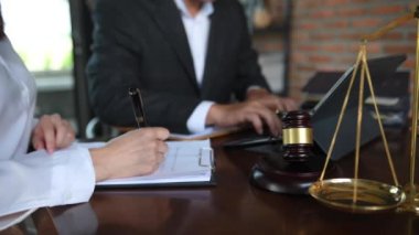 Businesswoman and lawyer discussing contract papers with brass scale on desk in office. Law, legal services, advice, justice and law concept .