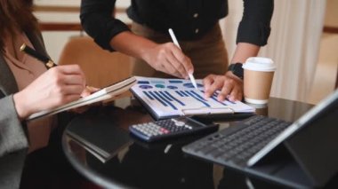 Businesspeople using laptop, tablet and document with charts