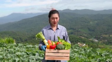 happy farmer girl holding vegetables at farm field.