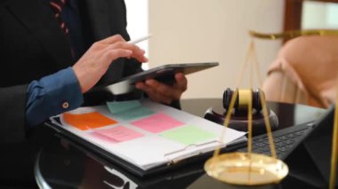 justice and law concept. Male judge in a courtroom the gavel, working with note and laptop and digital tablet computer on wooden table