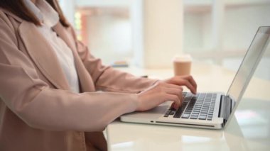 Genç kadın ofiste dizüstü bilgisayar kullanıyor. 