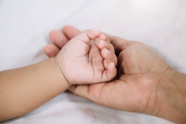 Close up baby hand in mother's hand