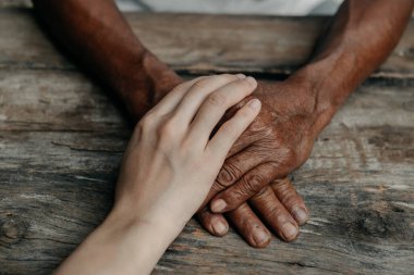 Tahta masada kırışık elleri destekleyen kız eli. Aile kavramına ilgi ve sevgi 