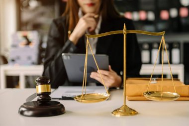 Tahta masada pirinç pullu bir kadın avukat var. Adalet ve hukuk kavramı. Tablet kullanan kadın 