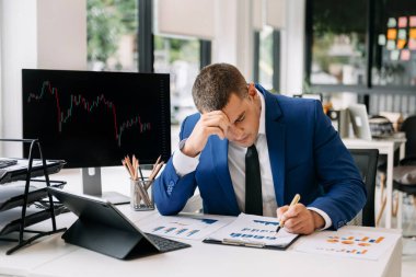 Hüsrana uğramış genç işadamı ofisinde çalışıyor ve notlar yazıyor. 