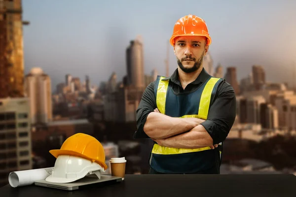 Engineer in helmet for workers security on buildings and management on the construction drawing plan near laptop working in Engineering tools on desk