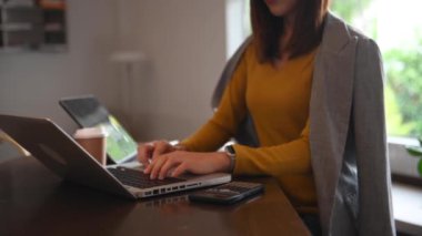 Masada çalışan iş kadınının hesap makinesi ve dizüstü bilgisayarıyla kısmi görüntüsü 