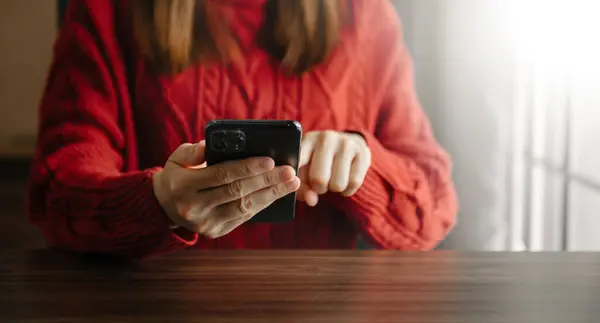 Close Mãos Mulher Jovem Digitando Smartphone Mulher Suéter Vermelho Mesa — Fotografia de Stock