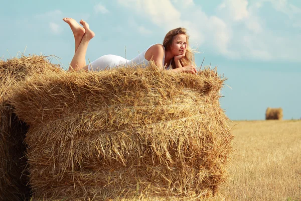 Girl on straw roll — Stock Photo, Image