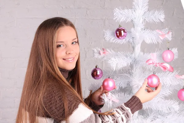 女の子はクリスマスツリーを飾る — ストック写真