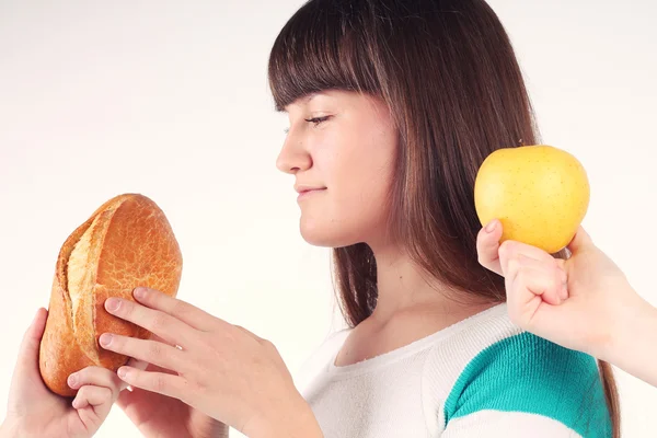 Pretty girl holding and biting loaf of bread — Stock Photo, Image
