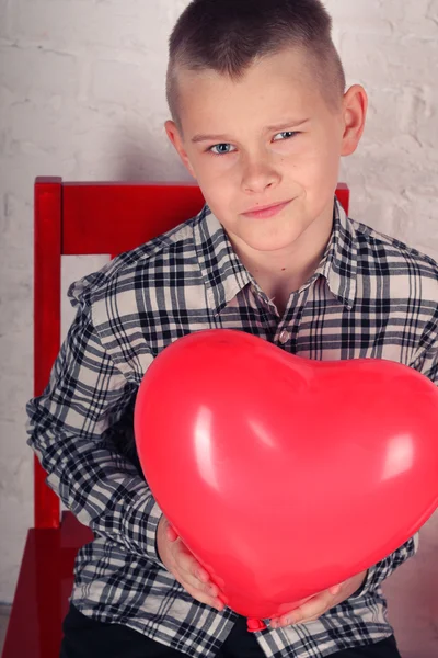 Menino com um balão em forma de coração — Fotografia de Stock