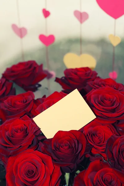 Rosas rojas con una etiqueta de regalo en blanco — Foto de Stock